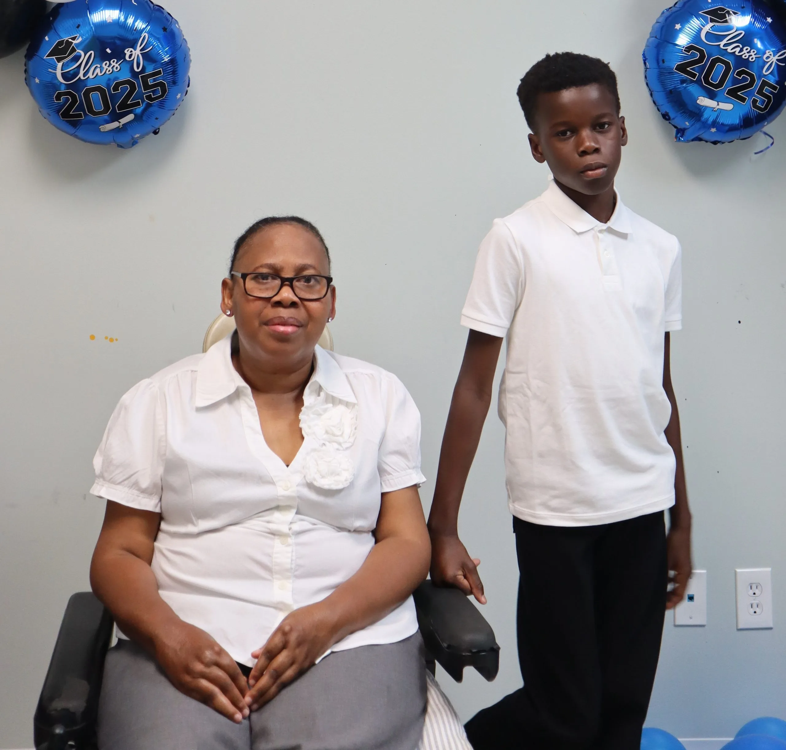 Woman in wheelchair next to standing 10-year-old boy 