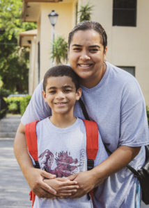 Client and her son posing in front of apartments