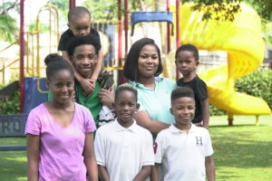 Family posing in front of playground