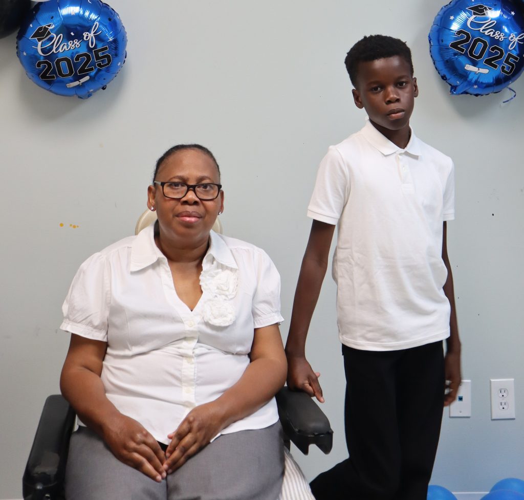 Woman in wheelchair next to standing 10-year-old boy 