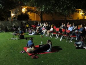 Families sitting outside watching a movie